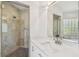 Modern bathroom featuring a tiled shower, vanity, and a unique glass block window at 6231 Bayshore Blvd, Tampa, FL 33611