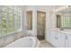 Bright bathroom featuring a soaking tub, walk-in shower and glass block window at 6231 Bayshore Blvd, Tampa, FL 33611