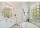 Well-lit bathroom featuring a tub, vanity, and natural light from a glass block window at 6231 Bayshore Blvd, Tampa, FL 33611