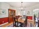 Formal dining room with red accent wall, hardwood floors, and a classic wooden china cabinet at 6231 Bayshore Blvd, Tampa, FL 33611