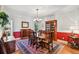 Dining room with hardwood floors, area rug, wooden furniture, and half red accent wall at 6231 Bayshore Blvd, Tampa, FL 33611