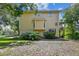 Side view of a yellow three-story home featuring a lush landscaping and mature trees at 6231 Bayshore Blvd, Tampa, FL 33611