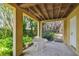 Covered patio with a concrete floor, a small round table, and surrounded by tropical plants at 6231 Bayshore Blvd, Tampa, FL 33611