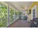 Inviting screened porch with ceiling fan, wicker furniture, and views of lush greenery at 6231 Bayshore Blvd, Tampa, FL 33611