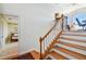 Bright staircase featuring wooden steps, white risers, and a wooden handrail leading to an upper level at 6231 Bayshore Blvd, Tampa, FL 33611