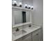 Double sink bathroom vanity with modern light fixtures at 37570 Teri Ct, Dade City, FL 33525