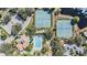 Aerial view of community amenities including a swimming pool, tennis courts, and lush landscaping at 1002 Pondview Ct, Tarpon Springs, FL 34689