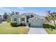 Charming single-story home features a well-manicured lawn, attached two-car garage, and neutral light-green exterior paint at 1002 Pondview Ct, Tarpon Springs, FL 34689