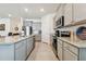 Open concept kitchen with gray cabinets and stainless steel appliances at 13204 Waterleaf Garden Cir, Riverview, FL 33579