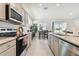 Open concept kitchen with island, gray cabinets, and stainless steel appliances at 13204 Waterleaf Garden Cir, Riverview, FL 33579