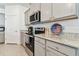 Modern kitchen with gray cabinets, granite counters, and stainless steel appliances at 13204 Waterleaf Garden Cir, Riverview, FL 33579