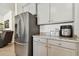 Stainless steel refrigerator with gray cabinets and granite countertops at 13204 Waterleaf Garden Cir, Riverview, FL 33579