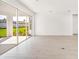 Bright living space with sliding glass doors to the patio, white walls, and light wood-look flooring at 4658 Freccia Loop, Wesley Chapel, FL 33543