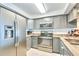 Bright kitchen with stainless steel appliances, gray cabinetry, and tile flooring at 2618 Gulf Blvd # 407, Indian Rocks Beach, FL 33785