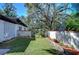 Landscaped backyard with a grassy area and block wall at 1802 E Hamilton Ave, Tampa, FL 33610