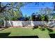 Large backyard with block wall, lush lawn, and mature trees at 1802 E Hamilton Ave, Tampa, FL 33610