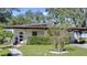Mid-century modern home with landscaped yard and walkway at 1802 E Hamilton Ave, Tampa, FL 33610