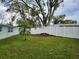 Large backyard with a white vinyl fence and a mature oak tree at 7344 Live Oak Ln, New Port Richey, FL 34653