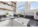 Farmhouse sink features granite countertops, open shelving, and stainless steel faucet at 2210 4Th N Ave, St Petersburg, FL 33713