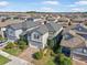 Two-story house aerial view, gray roof, light gray siding, and brick driveway at 9612 Little Bluestem Dr, Land O Lakes, FL 34637