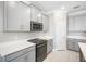 Modern kitchen with gray cabinets, white countertops, and stainless steel appliances at 9612 Little Bluestem Dr, Land O Lakes, FL 34637