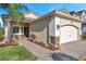 Tan house with a two-car garage and landscaped walkway at 2632 Tarragona Way, Wesley Chapel, FL 33543