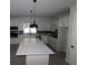 Modern kitchen with white cabinets, quartz countertops, and island at 679 Allora Ave, Nokomis, FL 34275