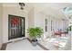 Front entrance with a black door, red wreath, and potted plant at 1300 Cedar Ct, Tarpon Springs, FL 34689
