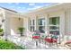 Front porch with brick columns, red chairs, and a small table at 1300 Cedar Ct, Tarpon Springs, FL 34689