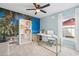 Home office with tropical wall mural, desk, and built-in shelving at 1300 Cedar Ct, Tarpon Springs, FL 34689