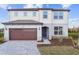 Two-story home with brick driveway, two-car garage and manicured lawn at 6753 Michael Favor Way, Wesley Chapel, FL 33545