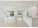 Open living space connecting the kitchen and living room, featuring tile floors and ample natural light at 6765 Michael Favor Way, Wesley Chapel, FL 33545