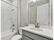 Bathroom with gray vanity, white quartz countertop, and marble-look tile shower at 2424 Wise River Ln, Zephyrhills, FL 33544