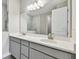 Double vanity bathroom with gray cabinets and marble shower at 2424 Wise River Ln, Zephyrhills, FL 33544