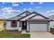 Single-story home with gray siding, red shutters, and a two-car garage at 2424 Wise River Ln, Zephyrhills, FL 33544