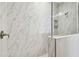 Elegant shower with marble-look tile and glass enclosure at 2424 Wise River Ln, Zephyrhills, FL 33544