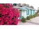 Cute beach cottage with vibrant bougainvillea and a brick walkway at 130 E Bay Dr, Treasure Island, FL 33706