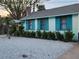 Quaint beach cottage with teal shutters and a gravel front yard at 130 E Bay Dr, Treasure Island, FL 33706