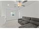 Spacious bonus room featuring a comfortable sectional sofa and ceiling fan at 9917 Spanish Lime Ct, Riverview, FL 33578