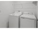 Convenient laundry room with washer, dryer, and overhead shelving at 9917 Spanish Lime Ct, Riverview, FL 33578