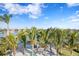 A waterfront backyard oasis offers a sandy beach with colorful chairs, palm trees, and serene water views at 105 Cordova Ne Blvd, St Petersburg, FL 33704