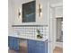 Stylish bar area featuring custom cabinetry, a patterned backsplash, stainless steel fridge, and elegant lighting at 105 Cordova Ne Blvd, St Petersburg, FL 33704