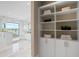 Luxurious bathroom with walk-in shower, lake view, storage shelves and cabinets, and tile flooring at 105 Cordova Ne Blvd, St Petersburg, FL 33704