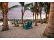 Beautiful waterfront beach area with colorful chairs, palm trees, and scenic views of the water and neighboring houses at 105 Cordova Ne Blvd, St Petersburg, FL 33704