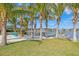 Colorful seating area with Adirondack chairs on sandy beach underneath palm trees facing a waterfront at 105 Cordova Ne Blvd, St Petersburg, FL 33704