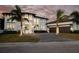 Stunning two-story home with a three-car garage, a paved driveway and lush tropical landscaping at 105 Cordova Ne Blvd, St Petersburg, FL 33704