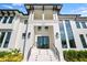 Eye-level shot of a grand two-story home featuring a covered entryway, a three-car garage, and decorative landscaping at 105 Cordova Ne Blvd, St Petersburg, FL 33704