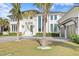 Magnificent two-story home with an attached three-car garage, lush landscaping, and a circular paver driveway at 105 Cordova Ne Blvd, St Petersburg, FL 33704