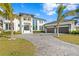 Beautiful two-story home with a paver driveway, a three-car garage, a covered entryway, and lush tropical landscaping at 105 Cordova Ne Blvd, St Petersburg, FL 33704