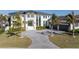 Stunning home showcasing a paver driveway, manicured lawn, tropical landscaping, and an attached three-car garage at 105 Cordova Ne Blvd, St Petersburg, FL 33704